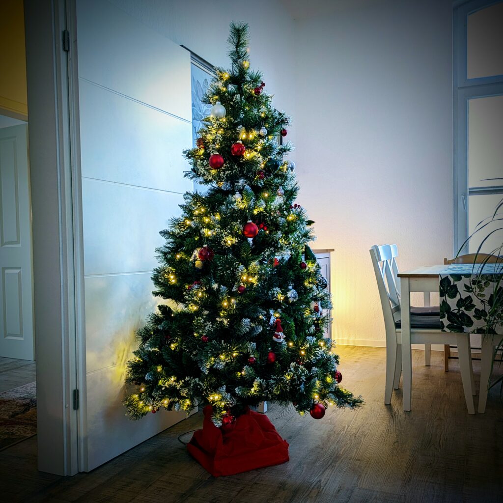 Green Christmas tree decorated with LED lights, red balls and a Minion. It's plastic but it was free.