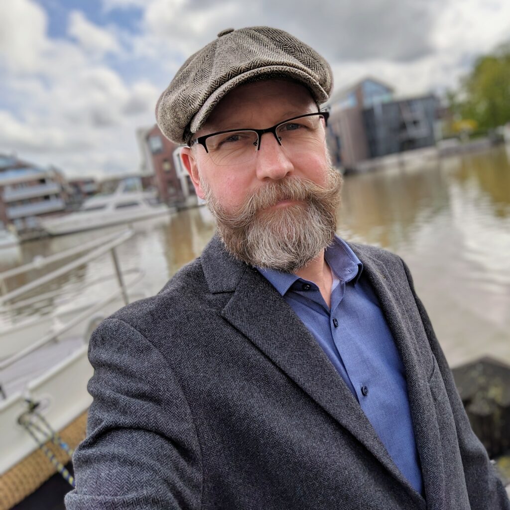 Beardfluencer sporting the Stetson flat cap, blue Olymp shirt and grey jacket 