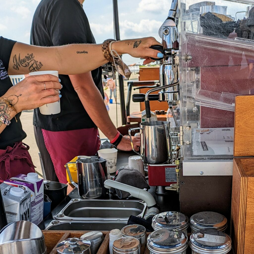 Barista making coffee at a mobile “coffeebike” at Norddeich beach