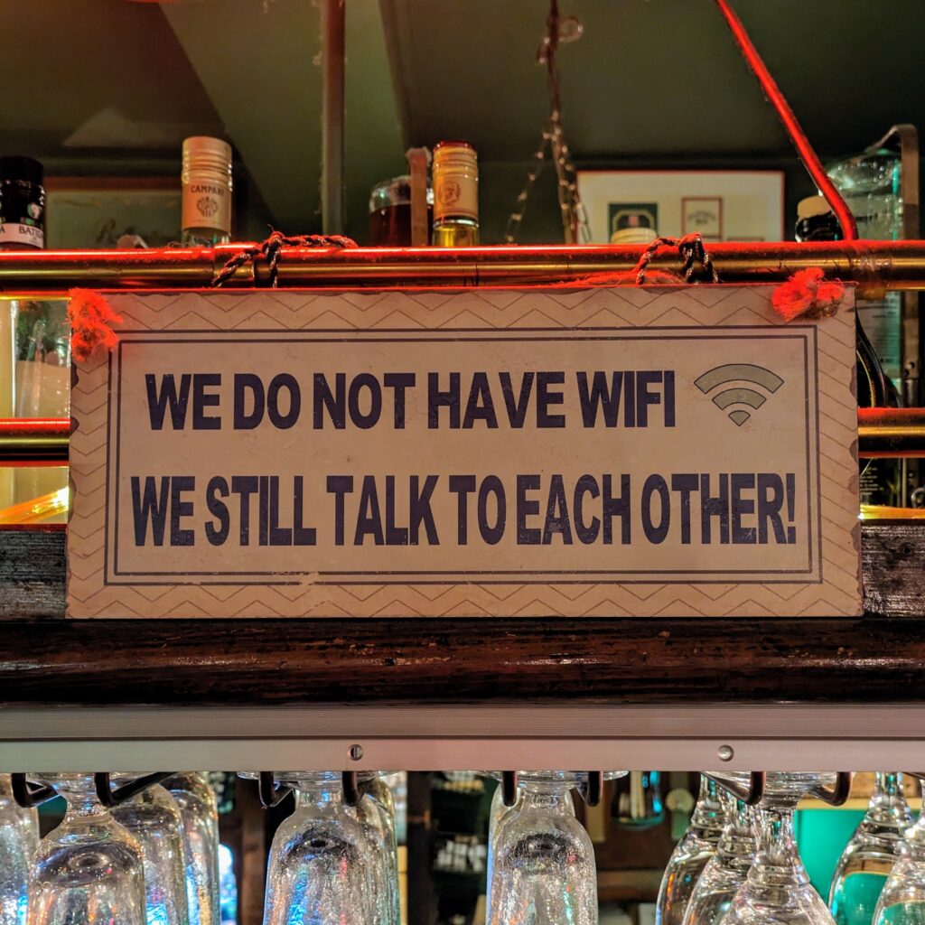 Sign above bar reading We don't have WiFi, we still talk to each other 